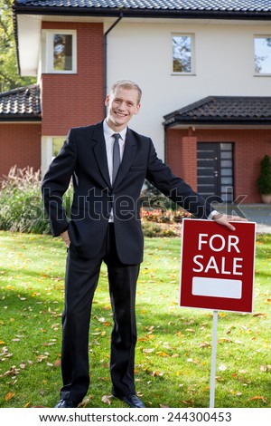 Young attractive real estate agent presenting the house for sale