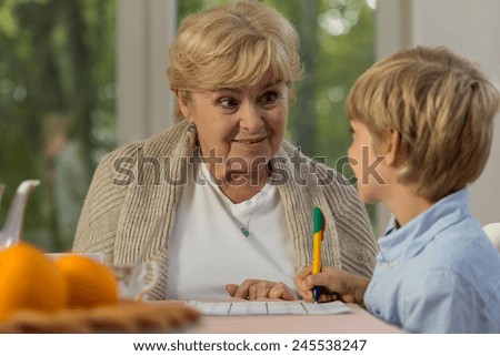 Happy little boy learning at home with his lovely granny