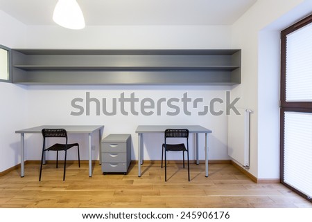 Two grey desks in modern empty study room