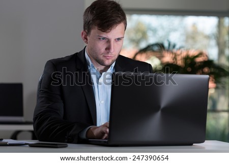 Office worker sitting at the table and using laptop