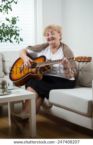 Portrait of elderly woman playing the guitar
