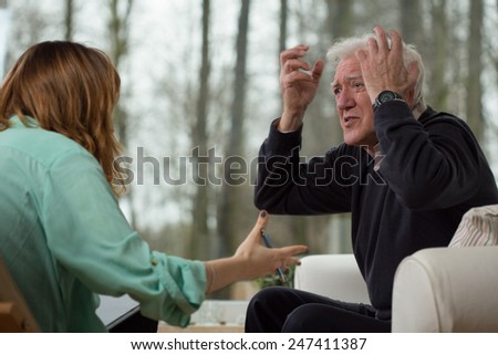 Depressed man showing his emotions during psychotherapy session