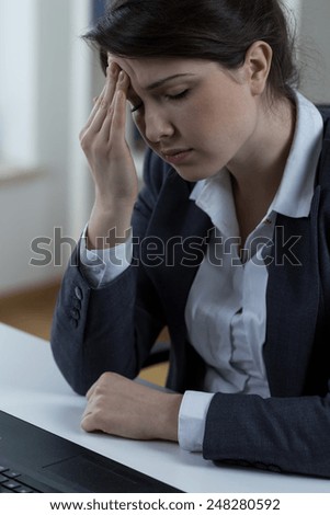 Woman with a lot of work having terrible migraine
