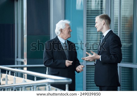 Senior chief and his employee talking out of business building