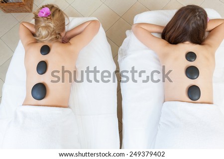 Friends during hot stone massage in beauty center