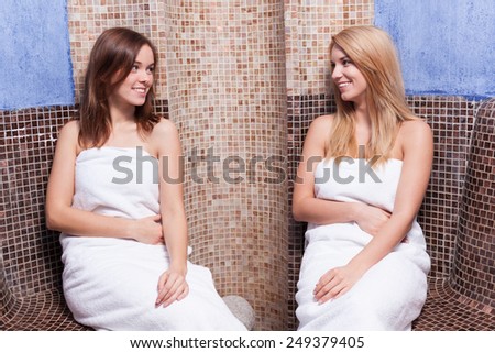 Attractive lady friends relaxing in spa center