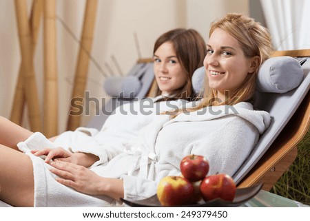 Lady friends sitting on deck chair in spa