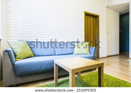 Blue sofa in the room with white bricks