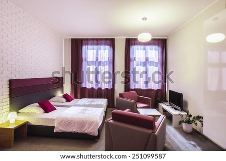 Spacious, violet hotel room with two single beds