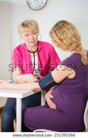 Experienced obstetrician measuring his pregnant patient blood pressure
