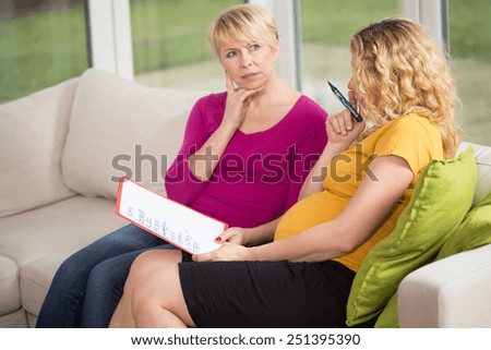 Pregnant woman and her mother choosing the name for baby