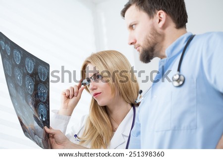 Young neurologists reading brain MRI at hospital
