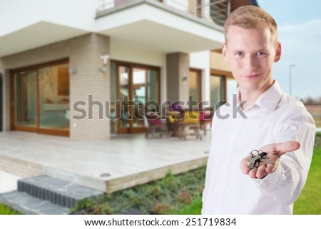 Young handsome architect giving the keys to new house