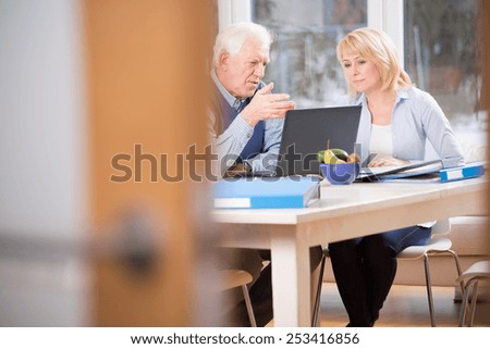 Two elderly colleagues talking about business cases