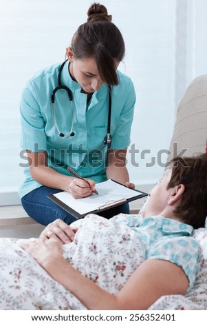Qualified female physician prescribing the medicine to sick woman