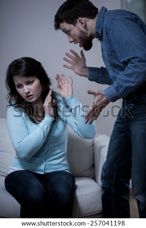 Young violent man arguing with his afraid wife