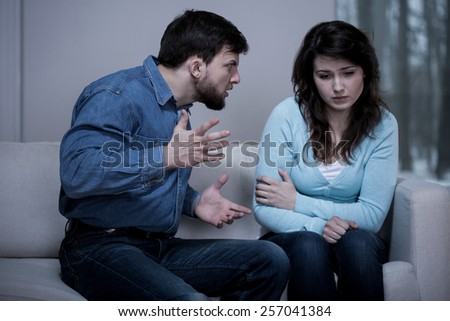 Young sad afraid woman and her violent screaming man