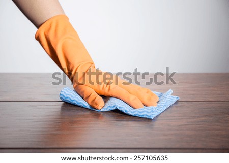 Close-up of hand in rubber glove with cloth