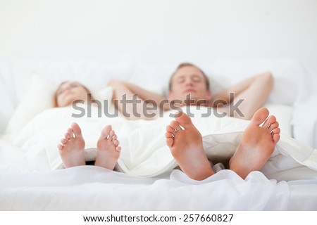 Close-up of the feet of young couple in bed