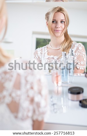 Ready bride looks at herself in the mirror