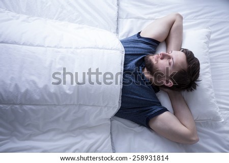 Image of young man sleeping after trying day