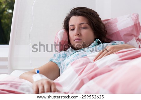 Young woman lying in hospital having intravenous therapy