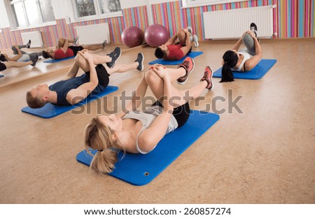 Fit people strengthening abdominal muscles during fitness classes