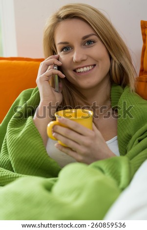 Lazy woman talking on the phone in bed