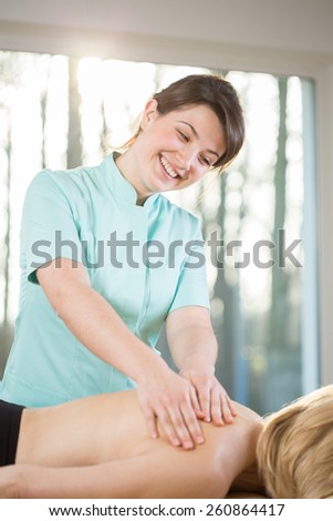 Image of smiling female masseur during her work