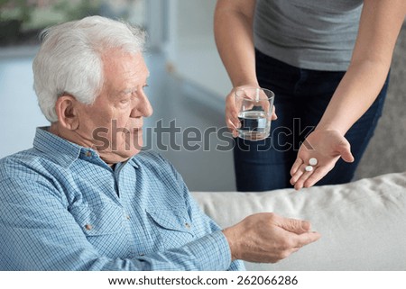 Close-up of ill senior man taking medicine