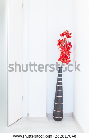 Close-up of red flowers in brown vase