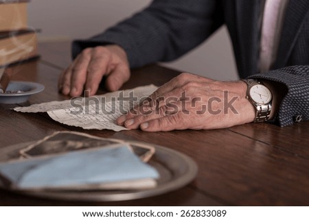 Close-up of male hands holding old letter