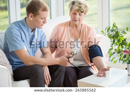 Man working as a nurse taking blood pressure