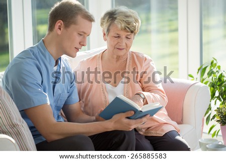 Male senior care assistant caring about elderly woman