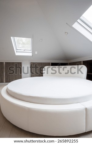 Round spacious bed in designed house, vertical
