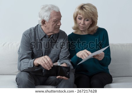 Old couple analyzing home budget and counting money
