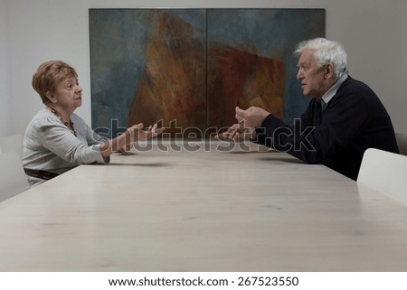 Older marriage sitting at the table and arguing