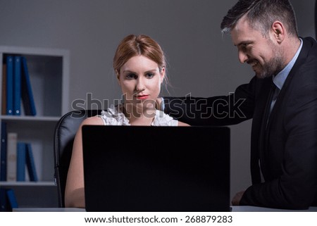 Handsome businessman flirting with young beautiful secretary