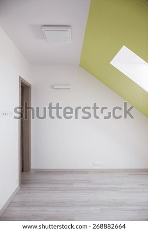 Interior of attic room with sloped ceiling