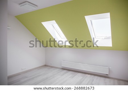 Empty attic room with white and green walls