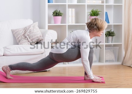 Sporty middle aged woman stretching her body