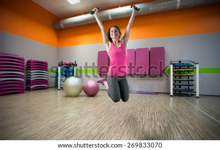 Happy sporty woman jumping at the gym
