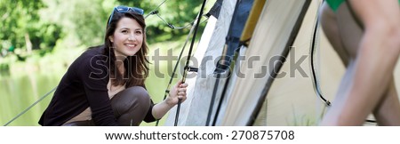 Girl pitching a tent on a camping trip