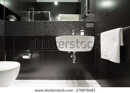 White basin on black wall in modern bathroom