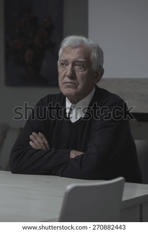 Sad elderly lonely man sitting at home