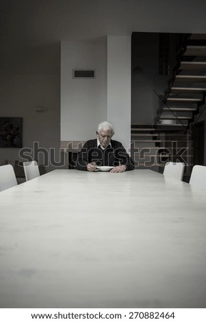 Photo of single older man eating dinner alone at home