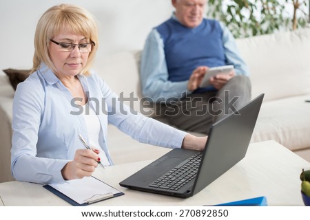 Elderly people working on laptop and tablet at home