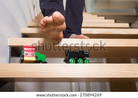 Close-up of man\'s foot and toys left on steps