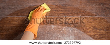 Cleaning soiled parquet in gloves with yellow rag