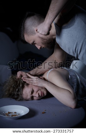 Violent strong man pulling his terrified wife\'s head